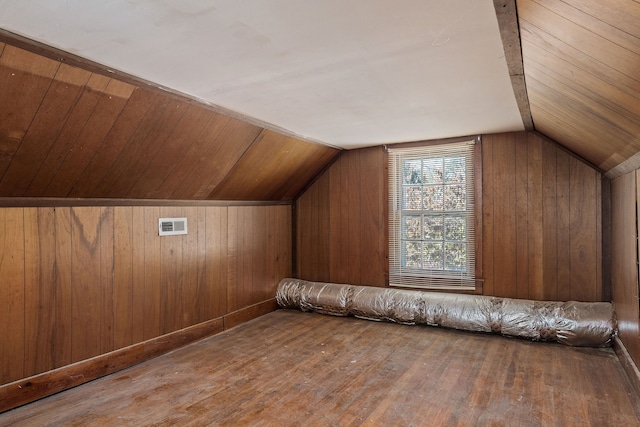 bonus room featuring wood walls, vaulted ceiling, and hardwood / wood-style floors