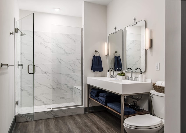 bathroom featuring toilet, vanity, a shower with shower door, and wood-type flooring