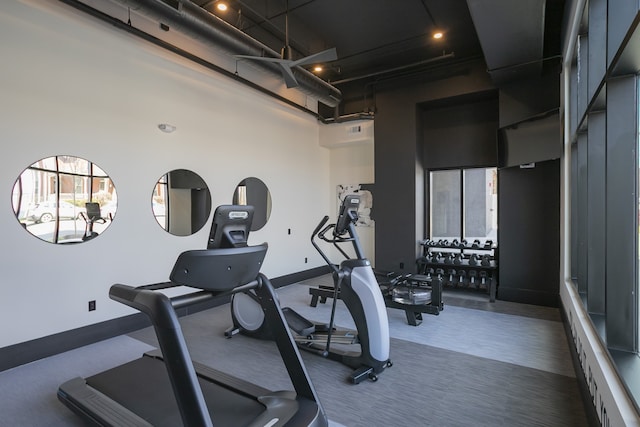 exercise room featuring a towering ceiling