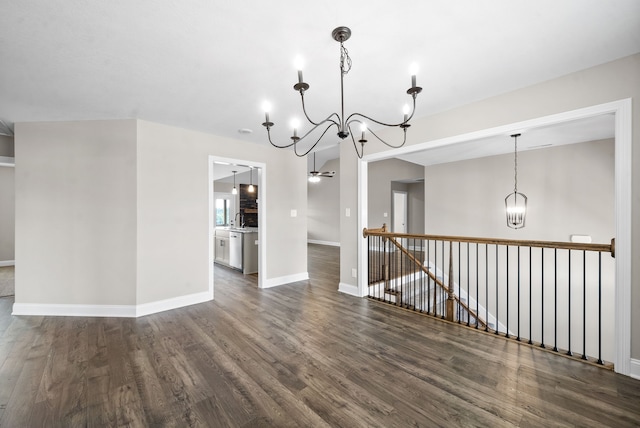 spare room with dark hardwood / wood-style floors and a notable chandelier