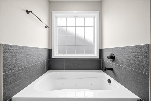 bathroom with a bathtub and tile walls