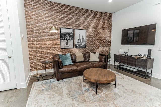 210 30th Ave N Unit 209, Nashville, TN 37203 - living room featuring concrete flooring, brick wall, and baseboards