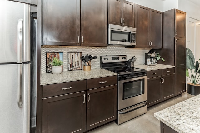 kitchen featuring dark brown cabinets, tasteful backsplash, appliances with stainless steel finishes, and light stone counters