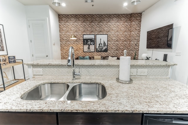 kitchen featuring sink and light stone counters