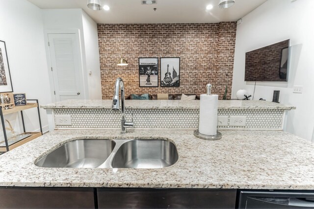 210 30th Ave N Unit 209, Nashville, TN 37203 - kitchen featuring a sink, backsplash, dark brown cabinets, and light stone countertops