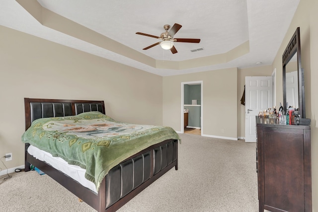 bedroom featuring a raised ceiling, carpet flooring, and ceiling fan