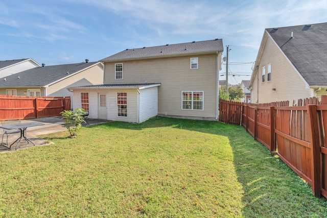 back of property with a patio area and a lawn