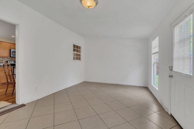 tiled spare room with a wealth of natural light