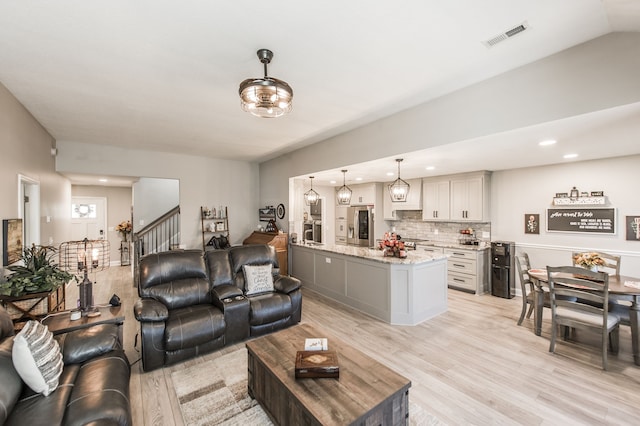 living room with lofted ceiling and light hardwood / wood-style flooring