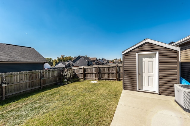 view of yard featuring a storage shed and central AC unit