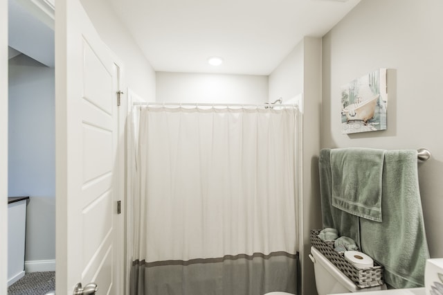 bathroom featuring toilet and a shower with curtain