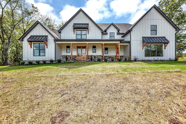 modern farmhouse style home featuring covered porch and a front lawn