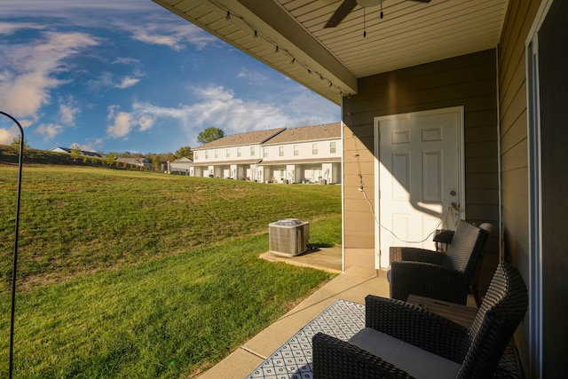 view of yard with central AC unit and ceiling fan