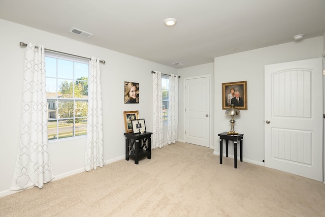 interior space with a wealth of natural light and light colored carpet