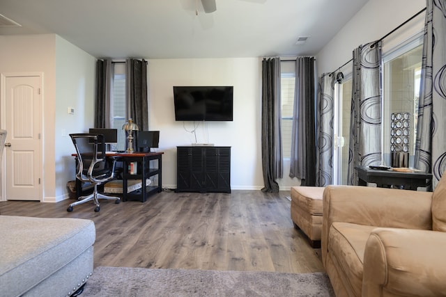 living room featuring wood-type flooring and ceiling fan