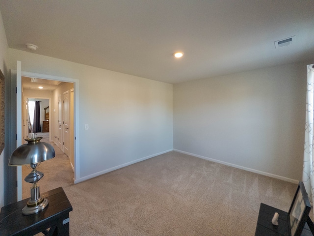 unfurnished room featuring light colored carpet