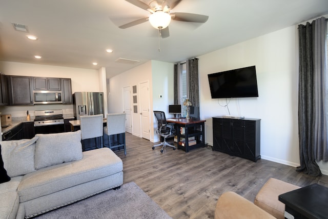 living room featuring ceiling fan and hardwood / wood-style floors