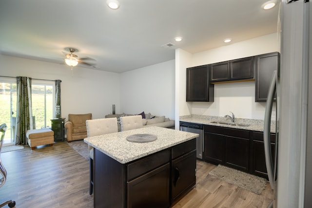 kitchen with a center island, stainless steel appliances, sink, and light wood-type flooring