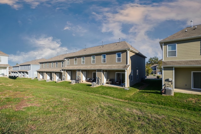 back of house with a patio and a lawn