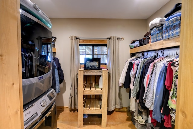 spacious closet featuring stacked washer / dryer and light carpet