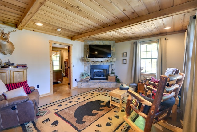 tiled living room with beam ceiling, a stone fireplace, and wood ceiling