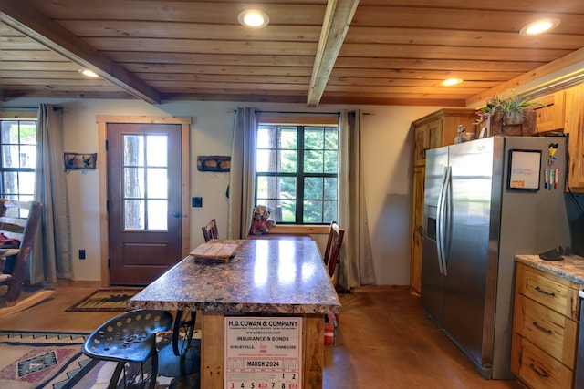 kitchen with beam ceiling, wooden ceiling, dark stone countertops, stainless steel refrigerator with ice dispenser, and a center island