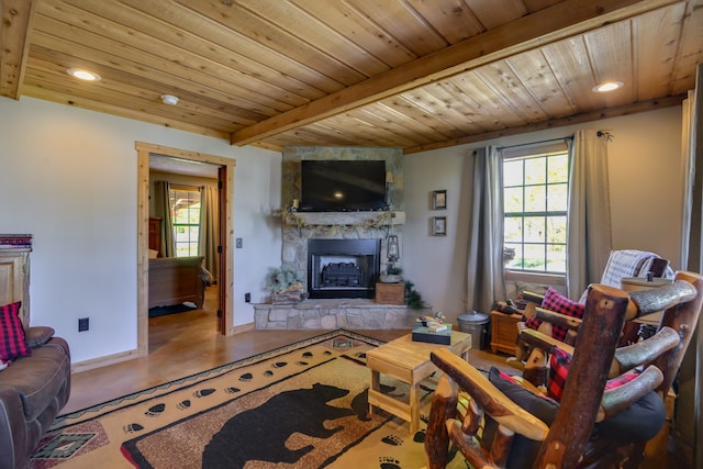 living room featuring a stone fireplace, beamed ceiling, a wealth of natural light, and wooden ceiling