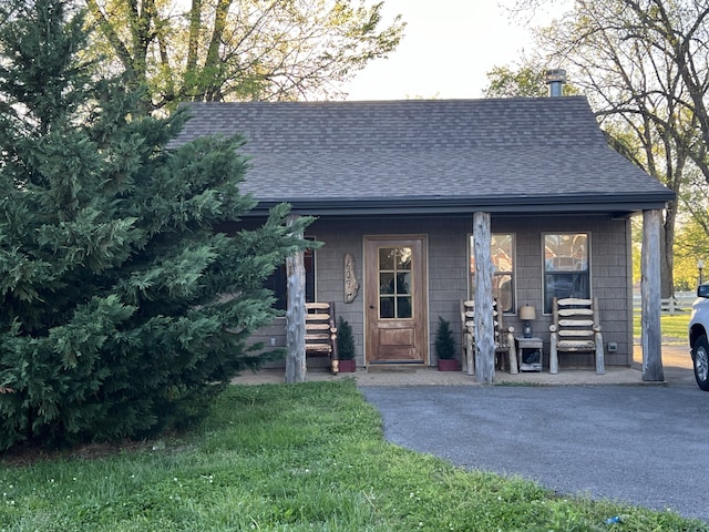 view of front of home featuring covered porch and a front lawn