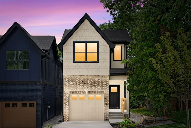 view of front of property featuring central air condition unit and a garage