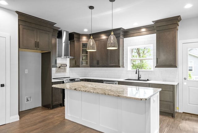 kitchen with light stone countertops, wall chimney range hood, sink, and dark hardwood / wood-style flooring