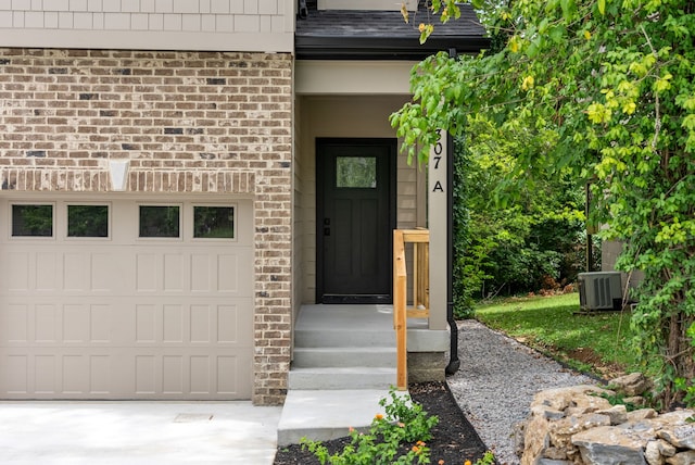 entrance to property featuring a garage and cooling unit