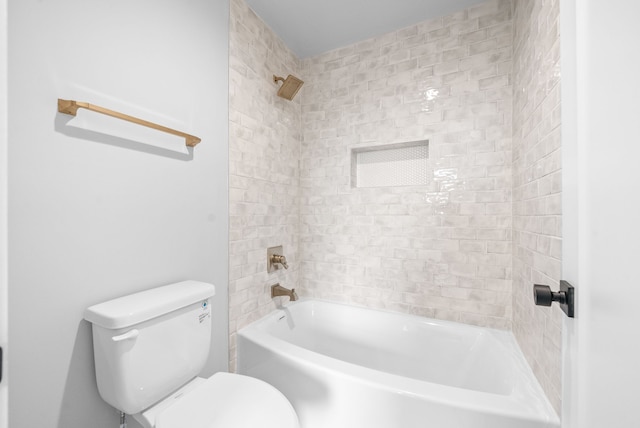 bathroom with toilet and tiled shower / bath