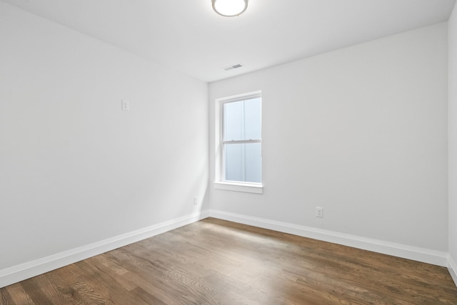 spare room featuring wood-type flooring