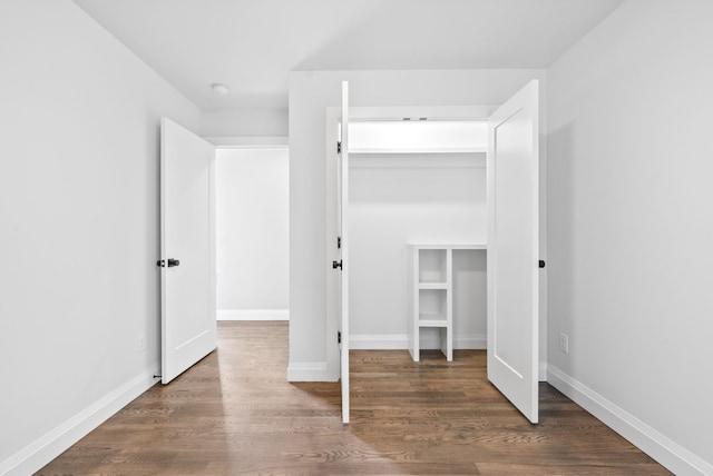 unfurnished bedroom featuring dark wood-type flooring and a closet