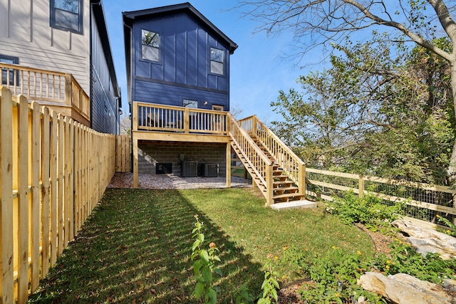 back of property with a wooden deck and a lawn