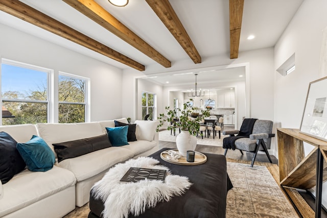 living room with beamed ceiling, a chandelier, and light hardwood / wood-style floors