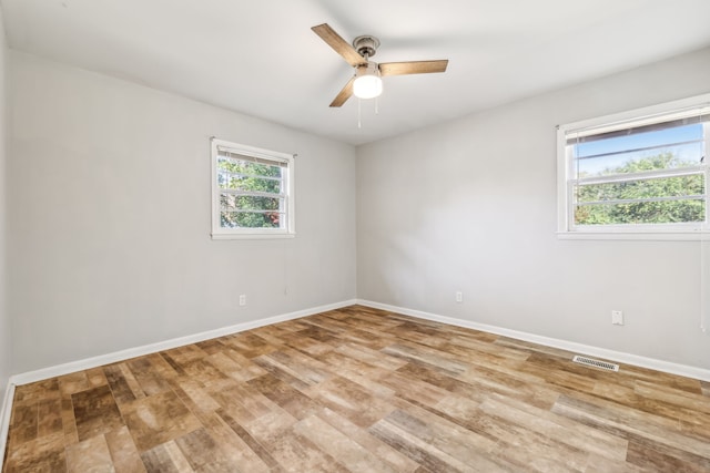 empty room with ceiling fan and light hardwood / wood-style flooring