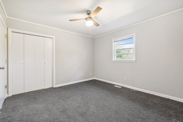 unfurnished bedroom featuring ceiling fan, crown molding, and dark carpet