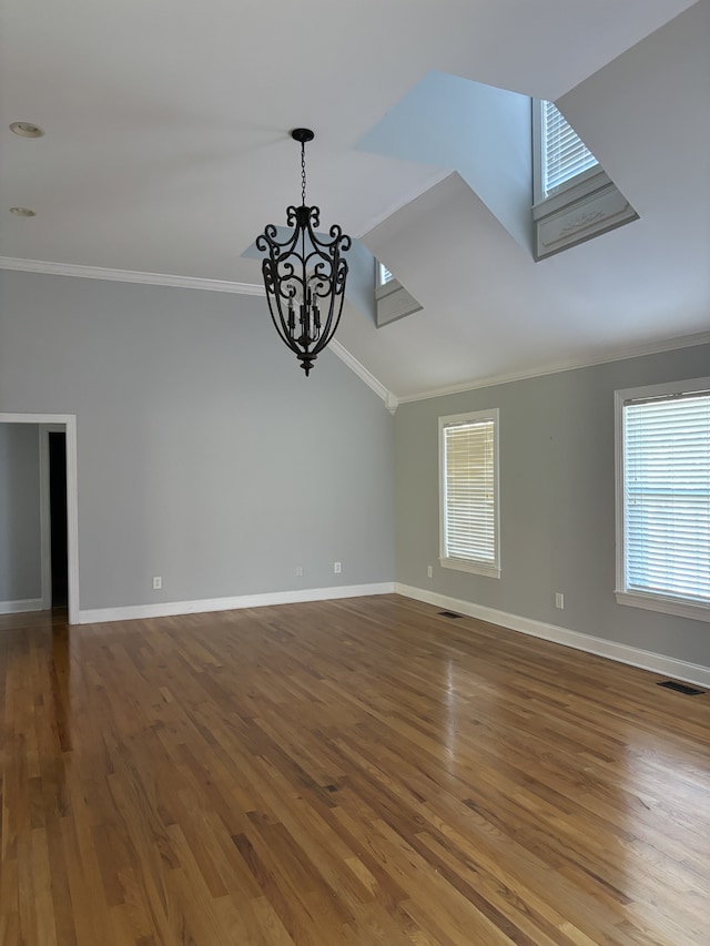 empty room with ornamental molding, a chandelier, and wood-type flooring