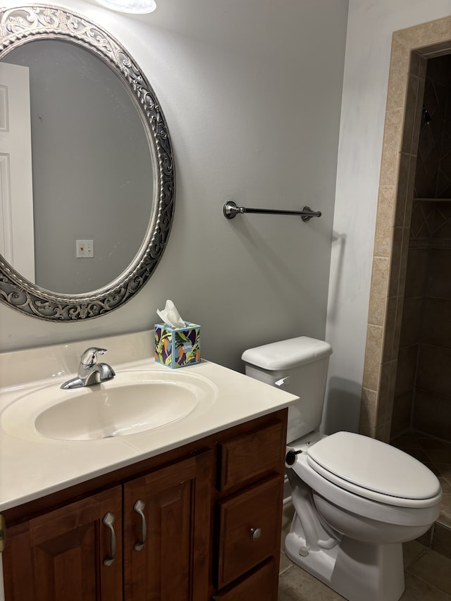 bathroom with toilet, walk in shower, vanity, and tile patterned floors