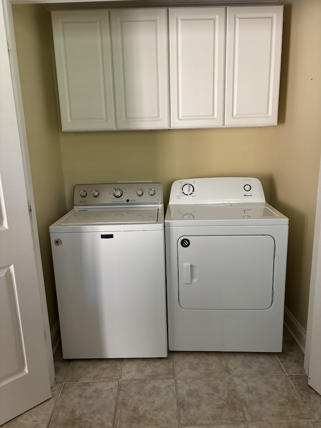 laundry area featuring independent washer and dryer, cabinets, and light tile patterned floors