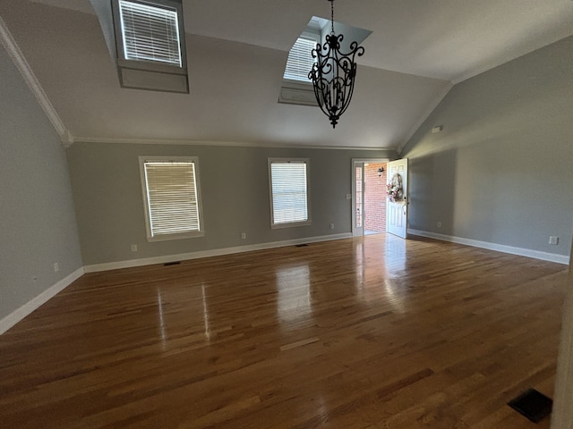 unfurnished living room featuring lofted ceiling, dark wood-type flooring, ornamental molding, and an inviting chandelier