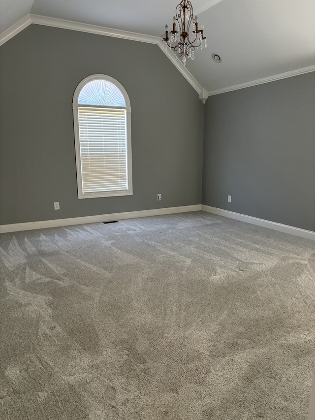 carpeted empty room featuring lofted ceiling, crown molding, and a notable chandelier