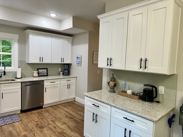 kitchen featuring sink, dishwasher, light wood-type flooring, and white cabinets