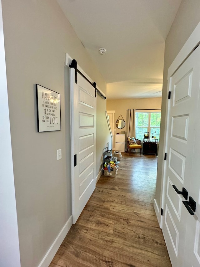 hall with hardwood / wood-style floors and a barn door