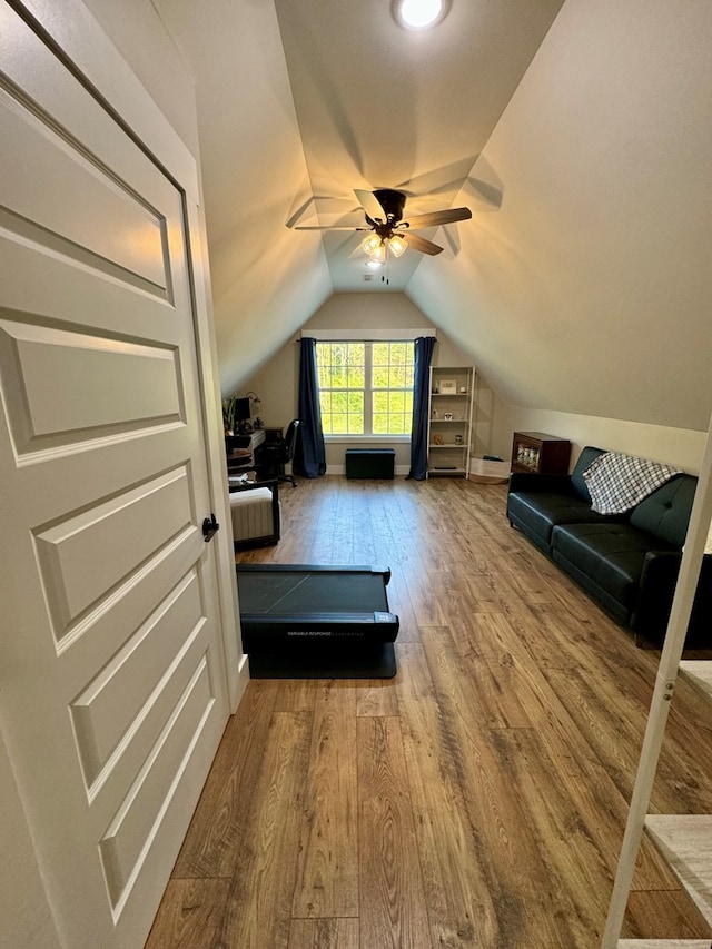 exercise room with lofted ceiling, wood-type flooring, and ceiling fan