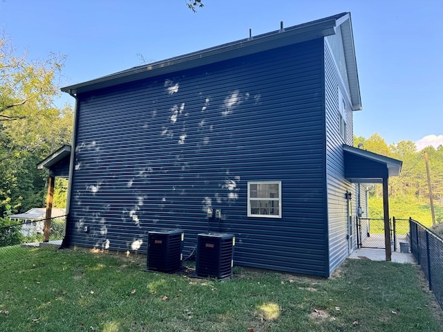 view of side of property with central air condition unit and a yard