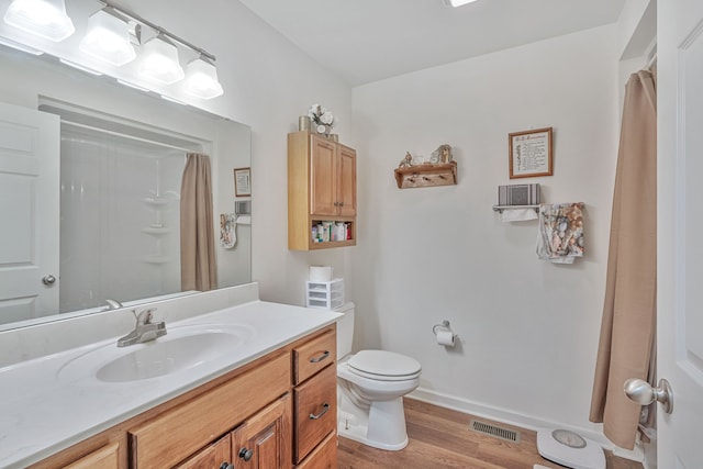 bathroom featuring vanity, toilet, hardwood / wood-style flooring, and a shower with curtain