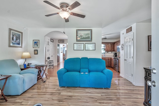 living room with light hardwood / wood-style flooring and ceiling fan