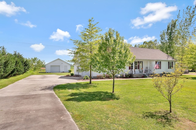 view of front of house featuring a front yard, a garage, and an outbuilding